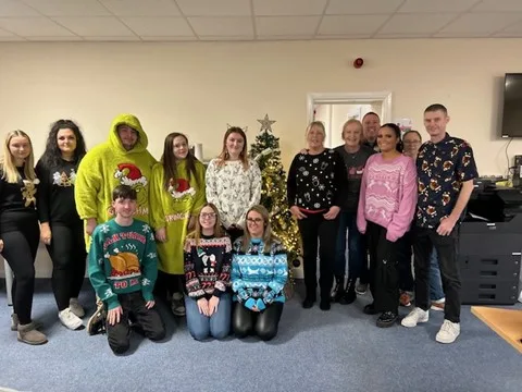 The One Sure team wearing Christmas jumpers