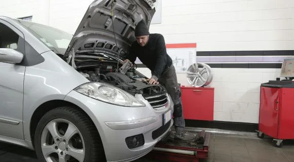 A mechanic fixing the inside of a car engine