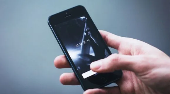 An iphone with the Uber taxi app loading on-screen